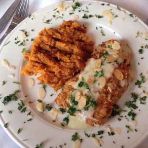 A plate with chicken and sweet potatoes on it.